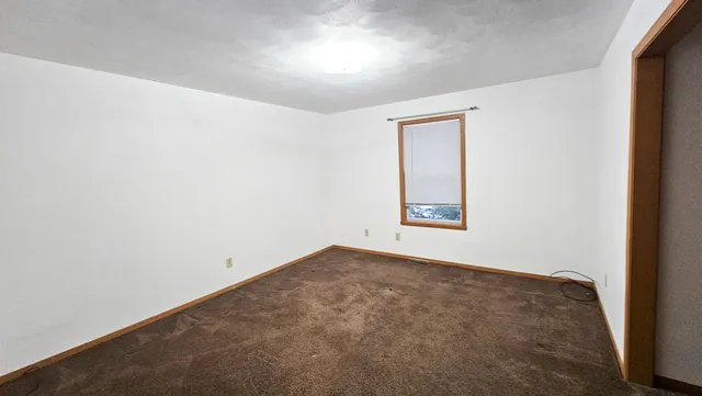 an empty room with windows and closet