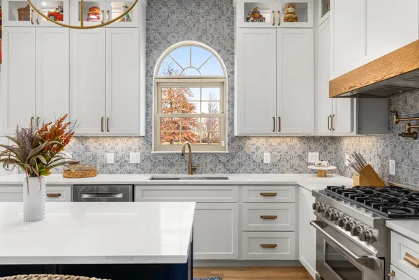 a kitchen with granite countertop a sink a stove and cabinets