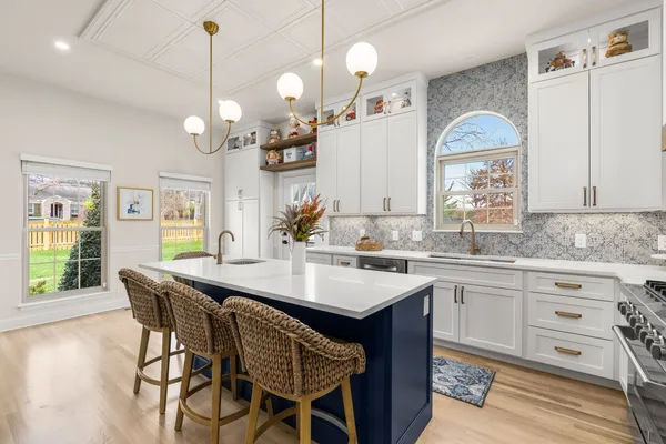 a kitchen with granite countertop a table chairs sink and wooden floor