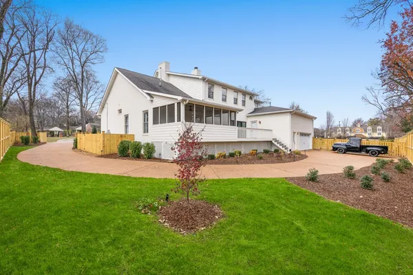 a front view of a house with a garden and trees