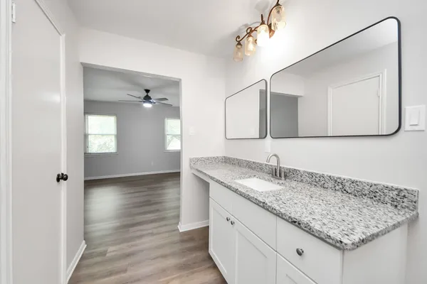 a bathroom with a granite countertop sink and mirror