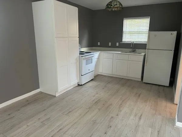 a kitchen with white cabinets and white appliances