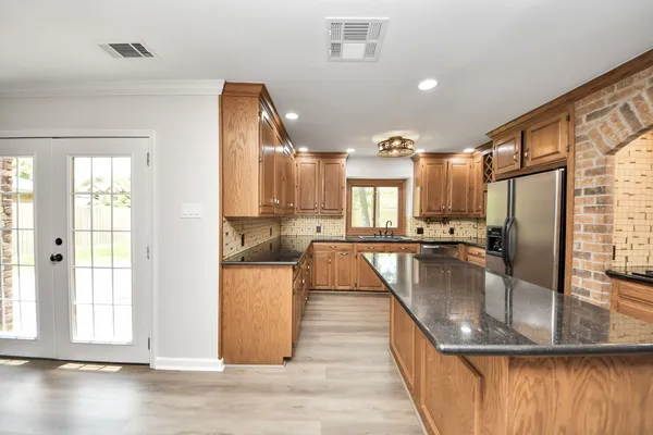 a kitchen with kitchen island a counter top space a sink stainless steel appliances and cabinets