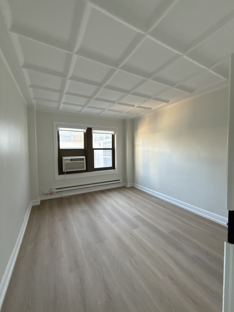 1211 North LaSalle Drive, Unit 1703 Chicago, IL 60610 - Photo 5 of 15 wooden floor in an empty room with a window
