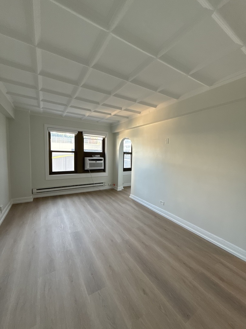 1211 North LaSalle Drive, Unit 1703 Chicago, IL 60610 - Photo 6 of 15 a view of empty room with wooden floor and fan