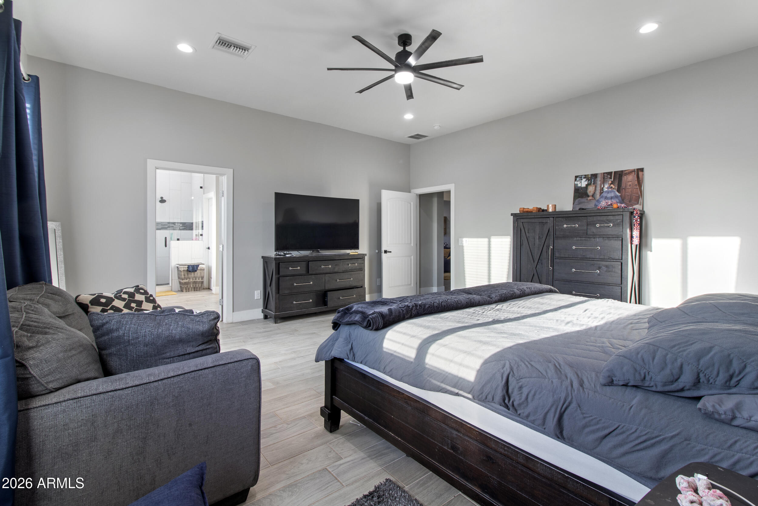 22531 West Harwell Road Buckeye, AZ 85326 - Photo 21 of 40 a bedroom with a bed couch and a flat screen tv