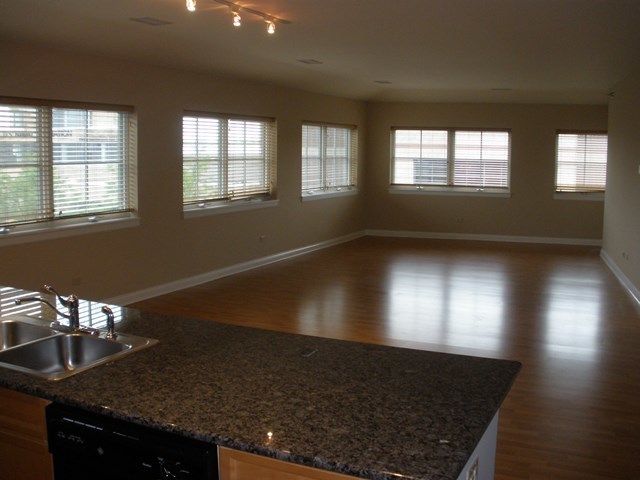 1801 Tower Drive, Unit E243 Glenview, IL 60026 - Photo 10 of 26 a view of an empty room with wooden floor and a window