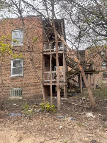 a front view of a house with large trees