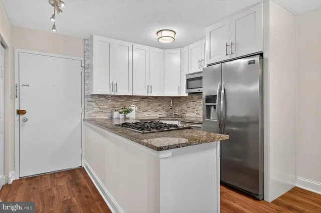 a kitchen with stainless steel appliances granite countertop a refrigerator and a stove