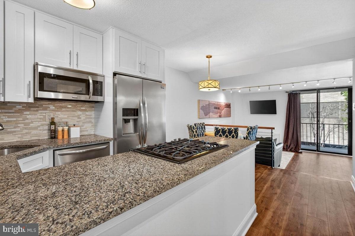 2201 L Street Northwest, Unit 316 Washington, DC 20037 - Photo 3 of 20 a kitchen with stainless steel appliances kitchen island granite countertop a stove refrigerator and microwave