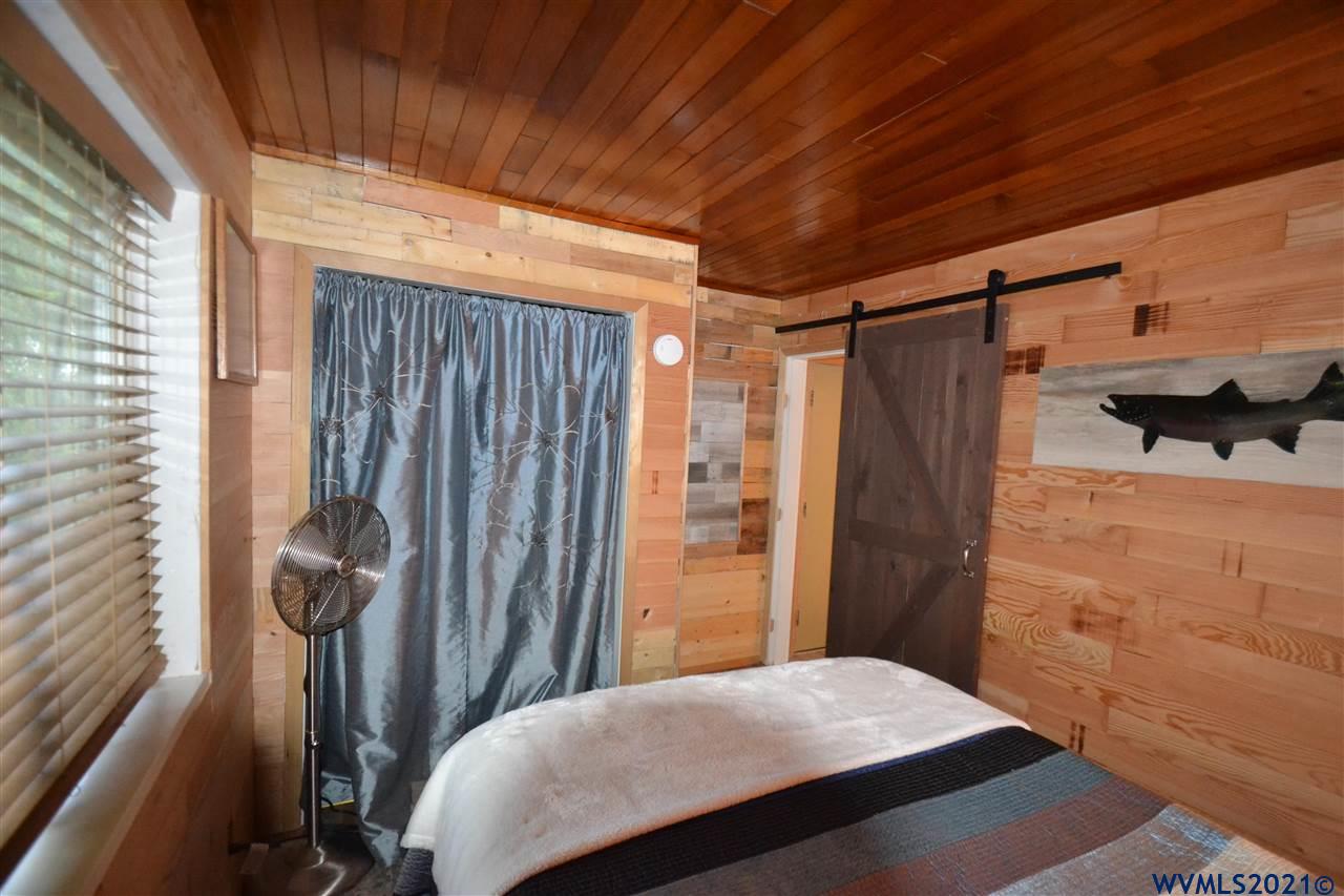 1690 Bayocean Road Northwest Tillamook, OR 97141 - Photo 15 of 25 a bedroom with a bed and a walk in closet