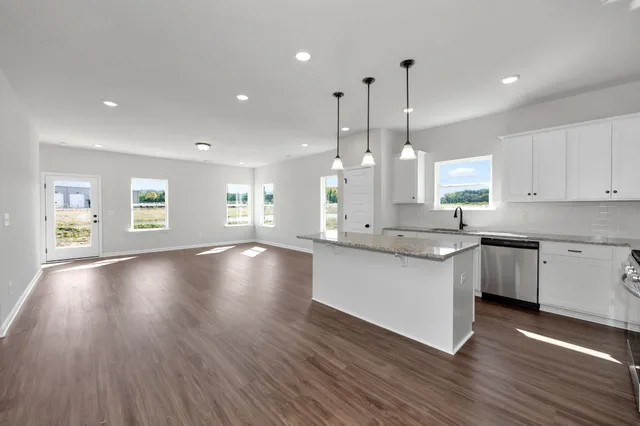 a large kitchen with lots of counter space a sink appliances and cabinets