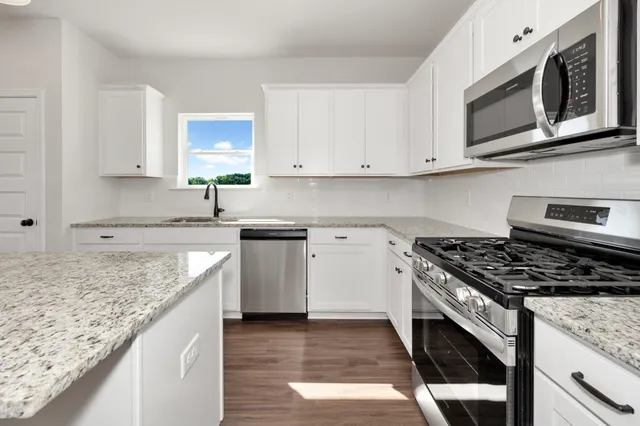 a kitchen with granite countertop cabinets stainless steel appliances and sink