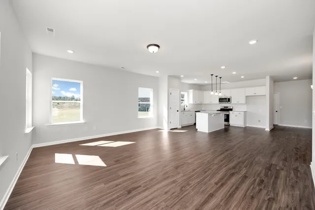 a view of kitchen with cabinets wooden floor and a window