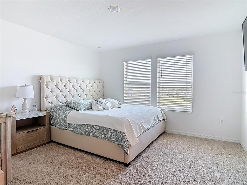 1146 Calico Pointe Circle Groveland, FL 34736 - Photo 23 of 54 a bedroom with a bed lamp and window