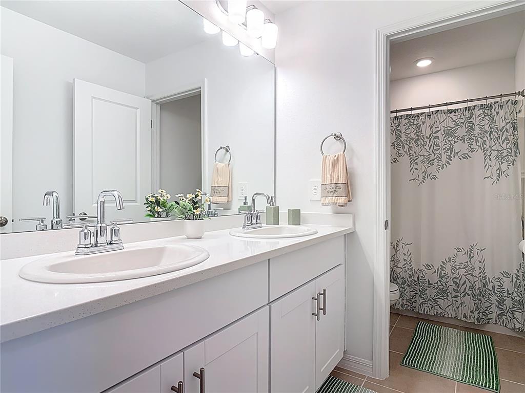 1146 Calico Pointe Circle Groveland, FL 34736 - Photo 37 of 54 a bathroom with a double vanity sink and a mirror