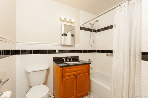 a bathroom with a sink a toilet a mirror and shower