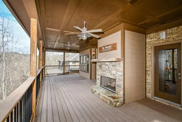 a view of a livingroom with wooden floor a ceiling fan and windows