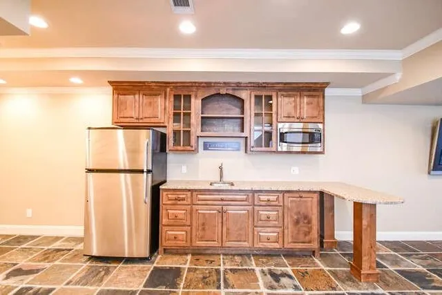 a kitchen with a sink a refrigerator and cabinets
