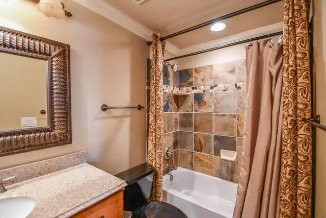 a bathroom with a granite countertop sink a mirror and a shower