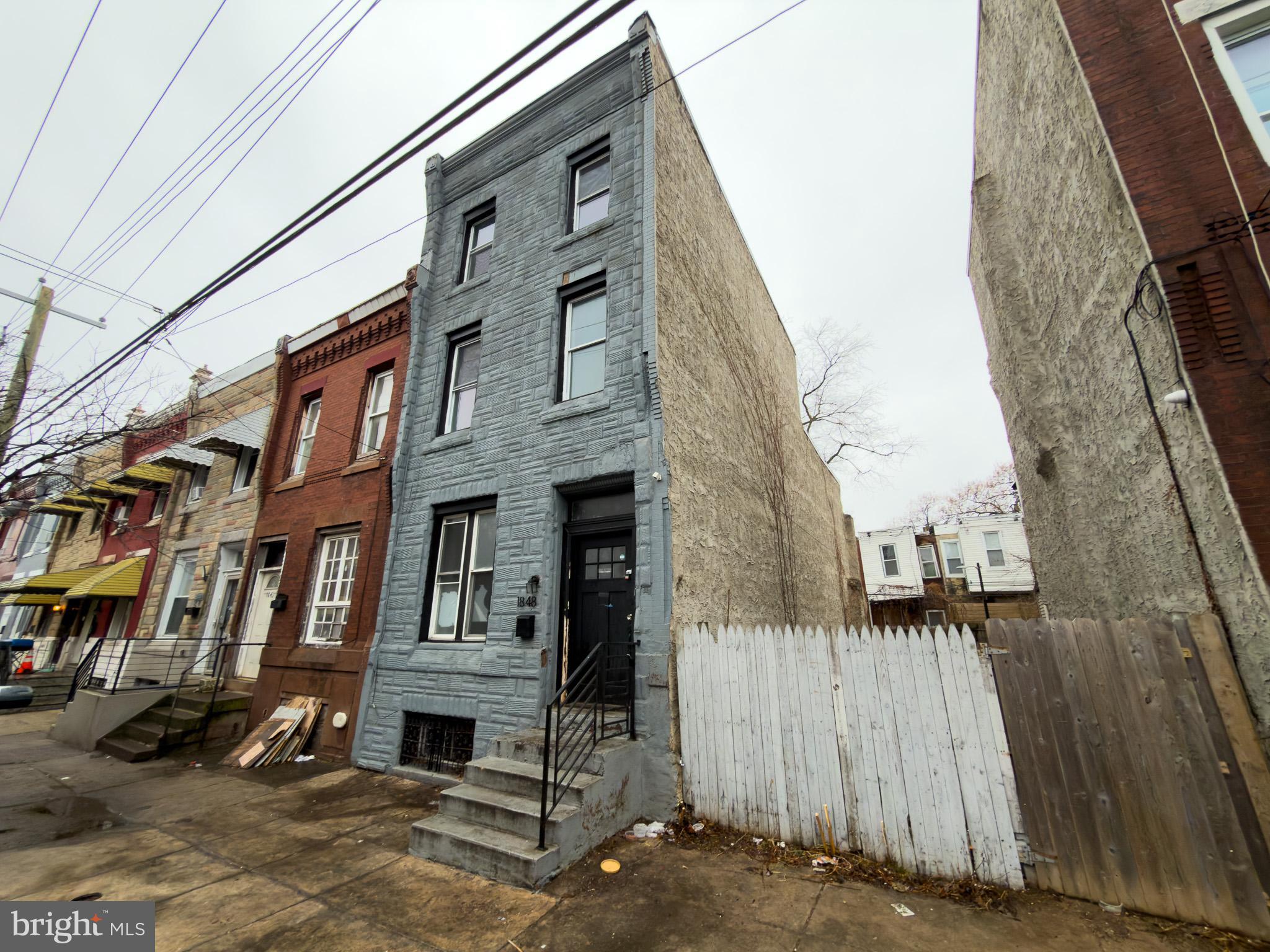 1848 North 27th Street Philadelphia, PA 19121 - Photo 28 of 29 a front view of a residential apartment building with a yard