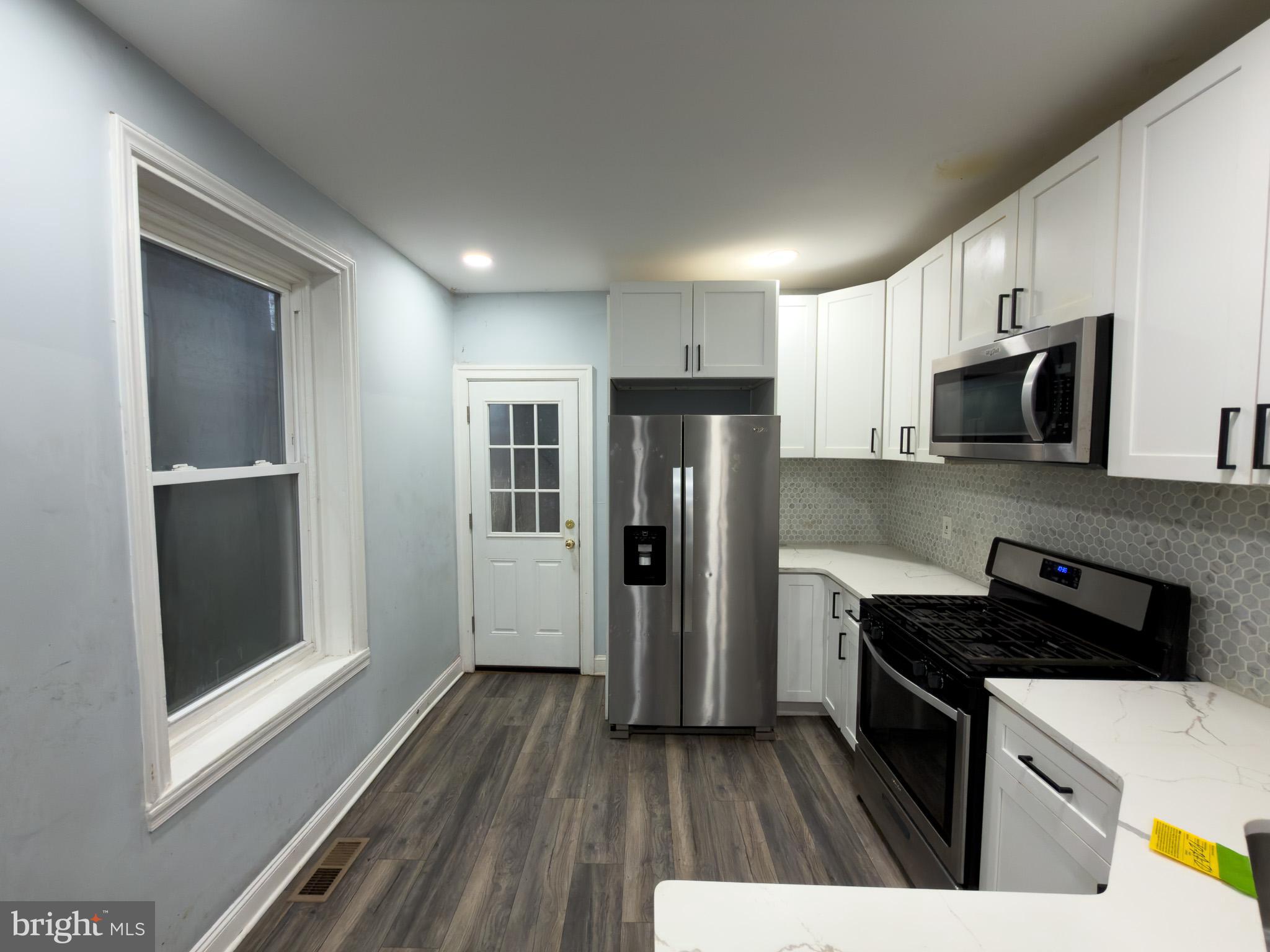 1848 North 27th Street Philadelphia, PA 19121 - Photo 6 of 29 a kitchen with a refrigerator and a stove top oven