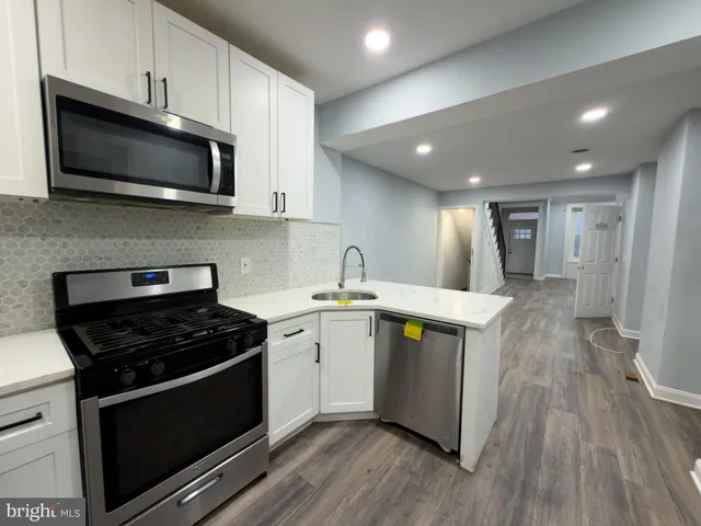 a kitchen with stainless steel appliances a stove microwave and sink