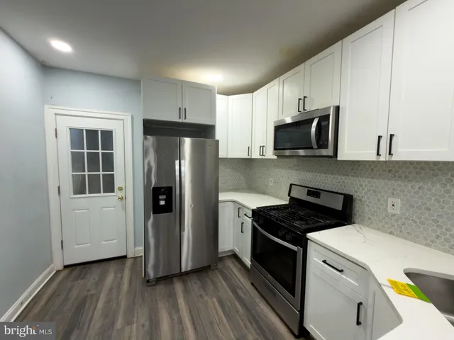 a kitchen with a refrigerator and a stove top oven