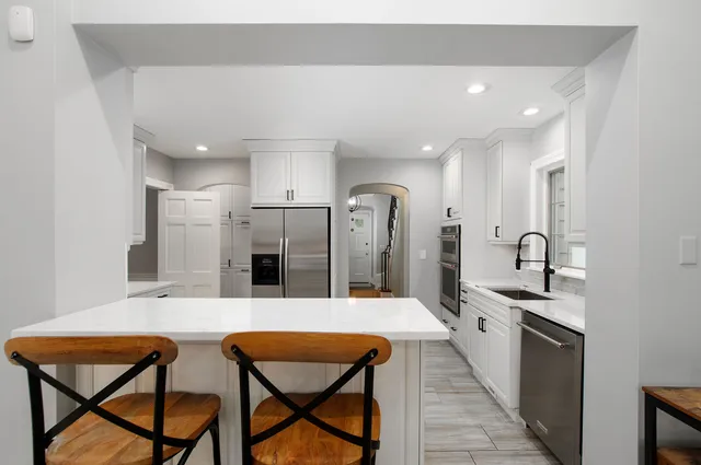 a large kitchen with stainless steel appliances kitchen island granite countertop a sink and cabinets