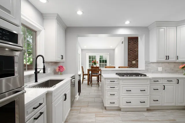 a kitchen that has a lot of cabinets in it and wooden floors