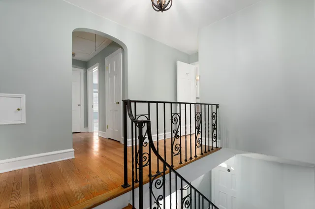 a view of a hallway with wooden floor and staircase