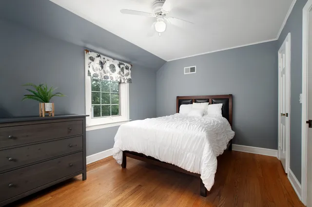 a bed sitting in a bedroom next to a window
