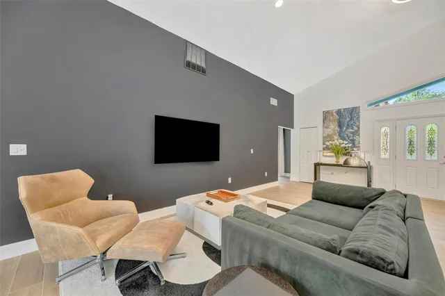 a living room with furniture kitchen view and a wooden floor