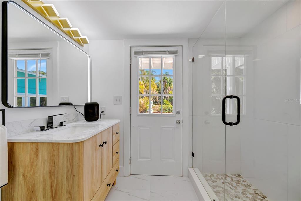 403 Longbow Trail Osprey, FL 34229 - Photo 45 of 99 a bathroom with a granite countertop sink a mirror and shower