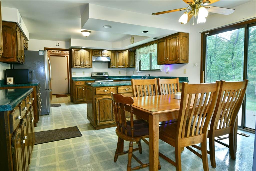 108 Davis Lane Freedom, PA 15042 - Photo 19 of 50 a kitchen with stainless steel appliances granite countertop a stove top oven a refrigerator a sink dishwasher with a dining table and chairs with wooden floor