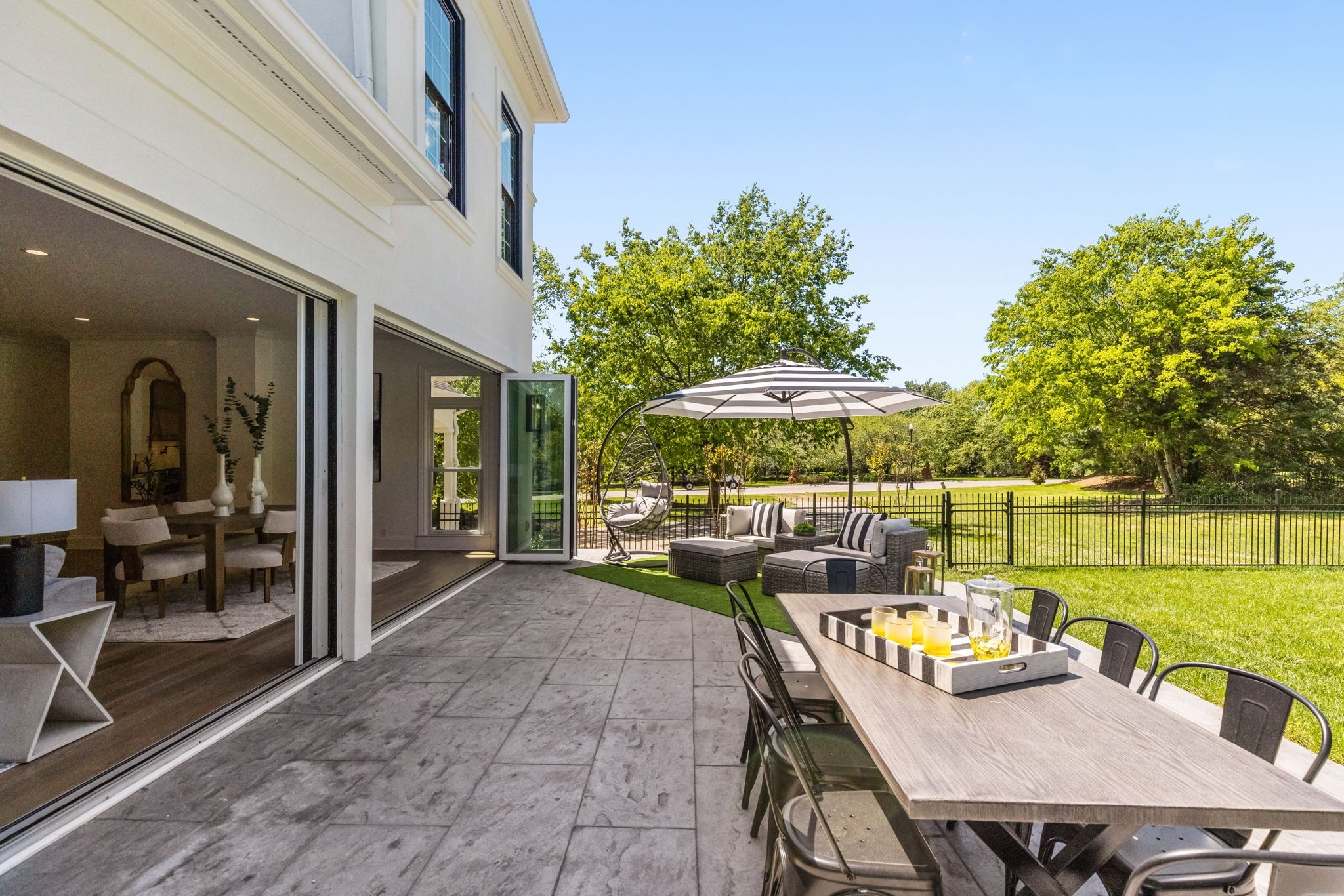 9050 Split Log Road Brentwood, TN 37027 - Photo 60 of 69 a view of a patio with couches table and chairs under an umbrella with a table and chairs
