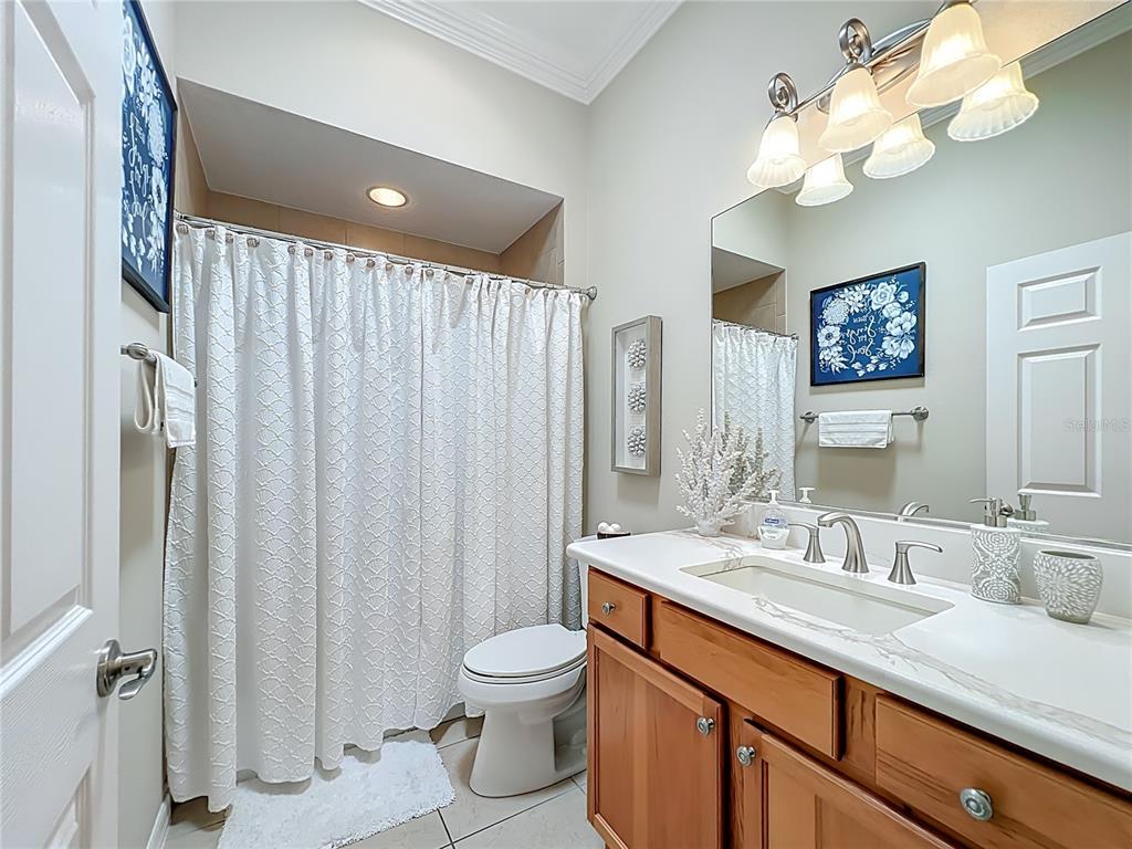 2875 Rain Lily Loop The Villages, FL 32163 - Photo 20 of 36 a bathroom with a sink vanity mirror and a toilet