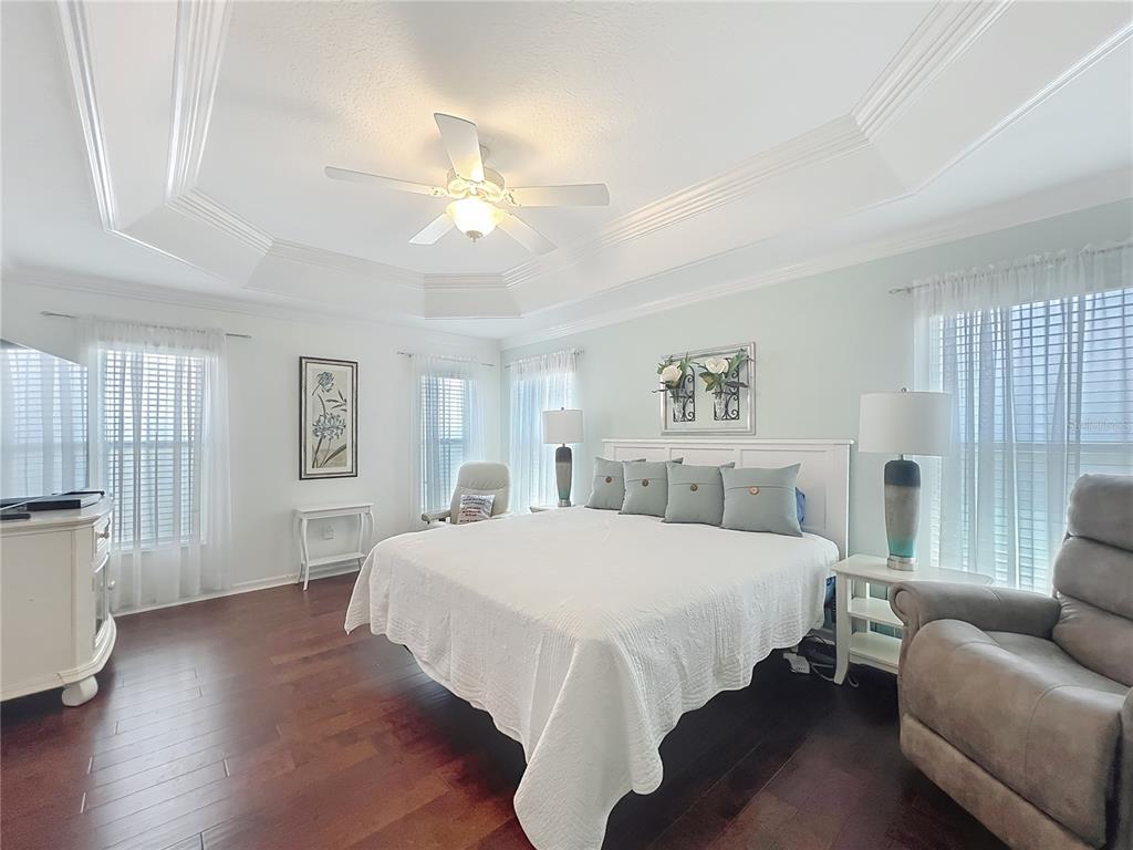 2875 Rain Lily Loop The Villages, FL 32163 - Photo 21 of 36 a bedroom with a large bed couch and a window