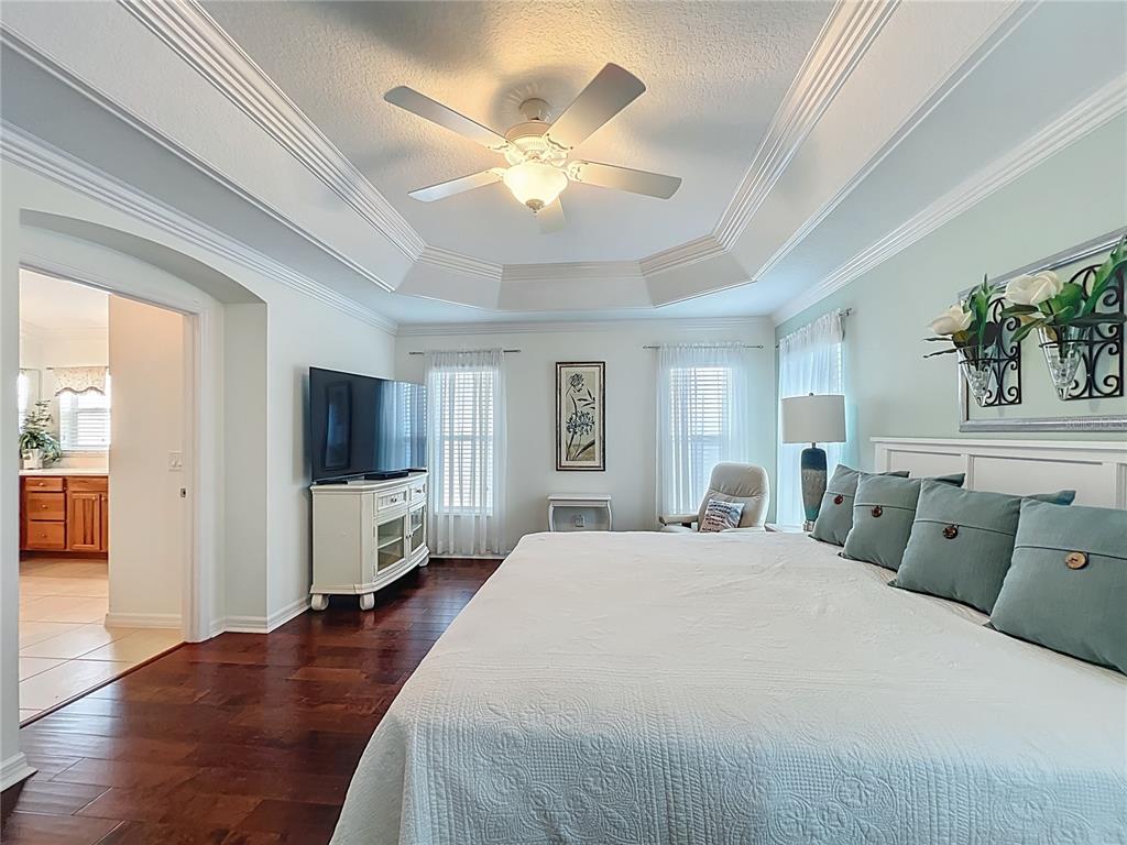 2875 Rain Lily Loop The Villages, FL 32163 - Photo 23 of 36 a spacious bedroom with a bed and a flat screen tv