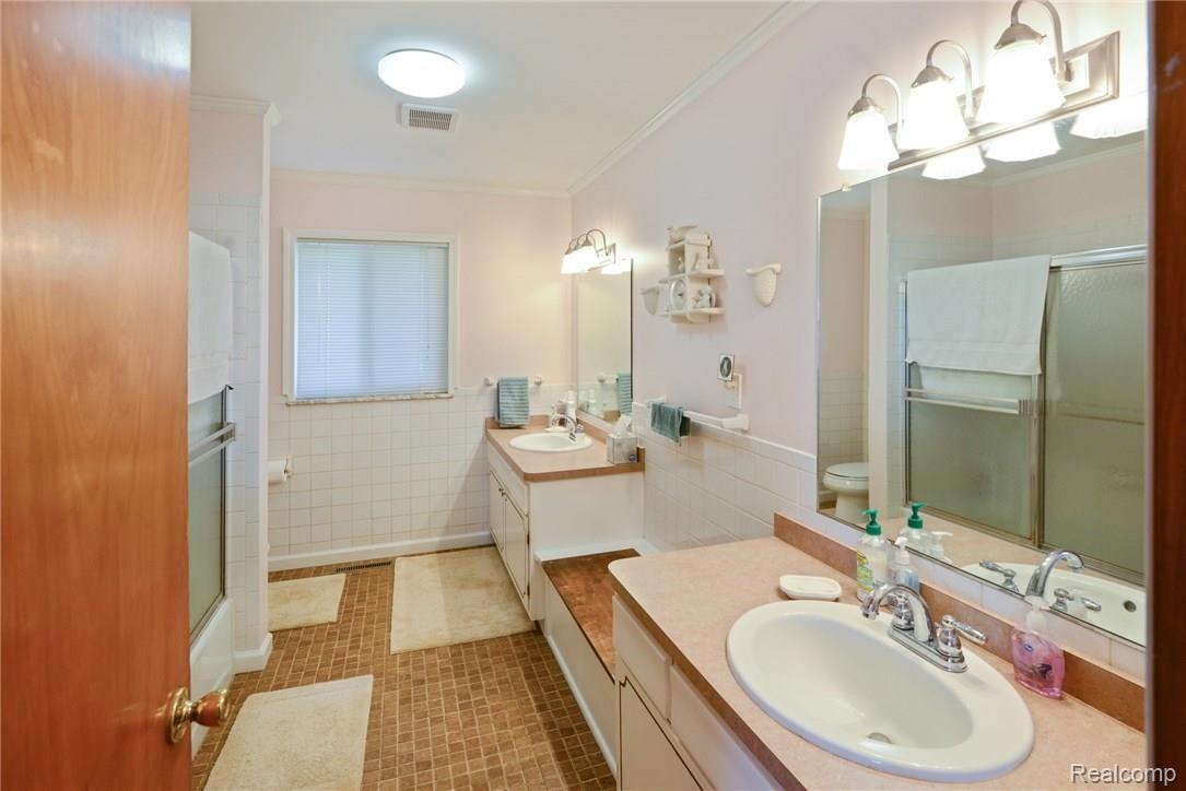 5821 West Hayner Road Fowlerville, MI 48836 - Photo 14 of 21 Full bath with double vanity and tub/shower combo
