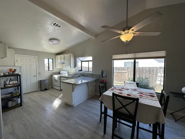 a dining room with furniture a chandelier and wooden floor