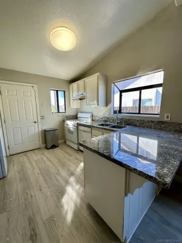 a kitchen with stainless steel appliances granite countertop a sink stove and cabinets