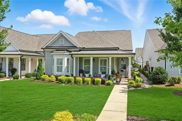a front view of a house with garden and lots of trees