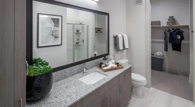 a bathroom with a granite countertop sink and a mirror