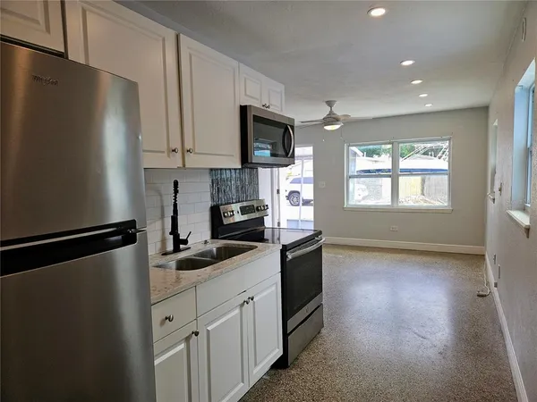 a kitchen with stainless steel appliances a refrigerator stove microwave and sink