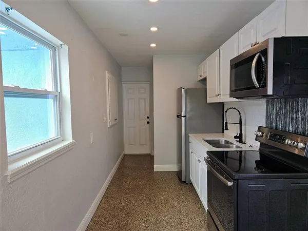 a kitchen with stainless steel appliances granite countertop a sink stove and microwave
