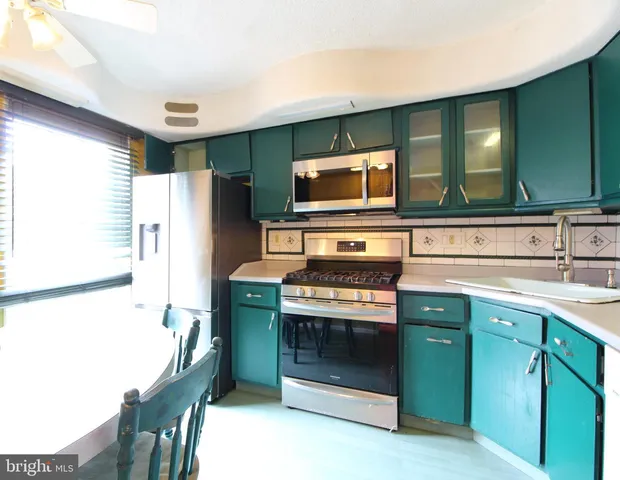 a kitchen with stainless steel appliances a stove microwave and refrigerator