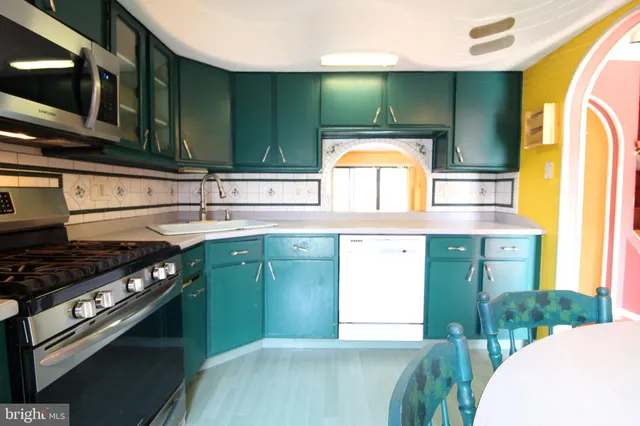 a kitchen with stainless steel appliances granite countertop a sink and a stove