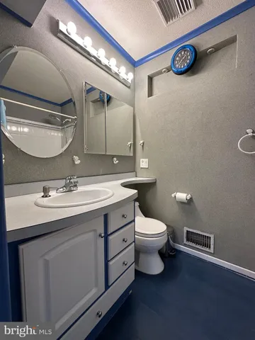 a bathroom with a toilet sink and mirror