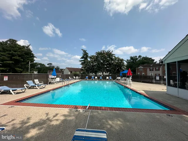 a swimming pool with lawn chairs